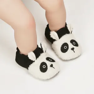 Close-up of fuzzy panda baby shoes with soft soles and elastic cuffs for warmth.