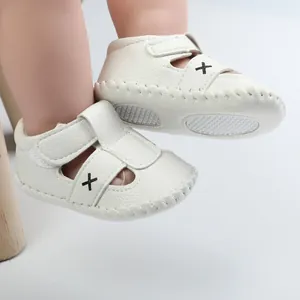 Nahaufnahme weißer, atmungsaktiver Baby-Lauflernschuhe mit rutschfester Gummisohle