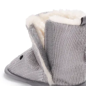 Nahaufnahme grauer Strick-Babystiefel mit weichem Kunstfellfutter und Klettverschluss