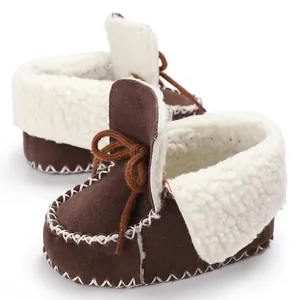 Dettaglio di scarpine per neonati in camoscio marrone con calda fodera in sherpa bianco