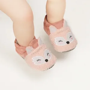 Detail of soft pink fuzzy baby indoor shoes with cute cartoon fox face embroidery.