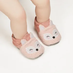 Detailed close-up of cute pink fox-themed fuzzy baby shoes on an infant's tiny feet.