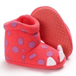 Close-up of red baby fleece winter boots featuring purple dots and cute white toe claws