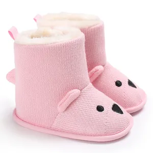 Detailansicht der rosa gestrickten Bären-Babystiefel mit warmem weißem Kunstfellfutter
