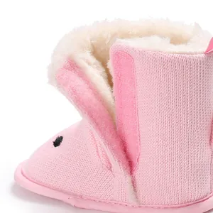 Detailansicht rosa gestrickter Babystiefel mit warmem weißem Kunstfellfutter und Klett