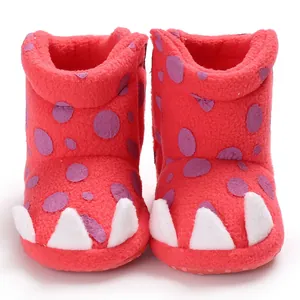 Detailed view of red baby winter boots with cute white claw design and soft fleece texture