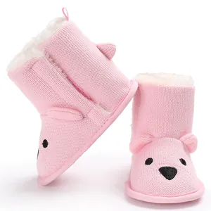 Detaillierte Nahaufnahme von rosa gestrickten Babystiefeln mit Bärengesicht und Weichfutter