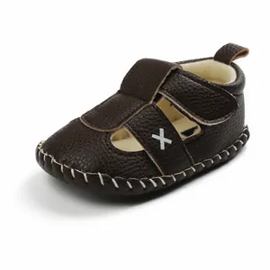 Dark brown leather baby walking sandals with white stitch details and Velcro closure