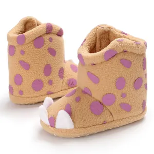 Close-up detail of cozy baby winter boots featuring purple polka dots and cute white claws