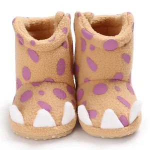 Detailed close-up of warm baby winter claw boots with soft fleece and purple polka dots.