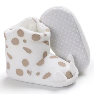 Detail view of white infant winter boots with brown polka dots and cute claw design
