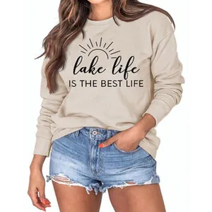 Détail d'un sweat-shirt beige pour femme avec l'imprimé 'Lake Life' et un soleil