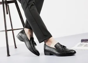 Detailed view of black woven leather loafers for men featuring elegant tassel accents.