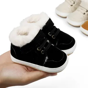 Detailaufnahme schwarzer Baby-Winterschuhe mit weißem Kunstfellfutter in der Hand