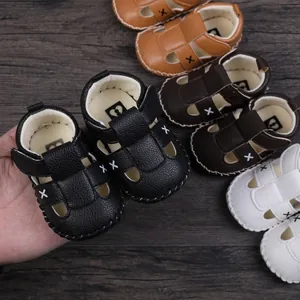 Close-up view of soft leather baby sandals with X-stitch pattern in multiple colors