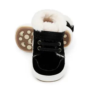 Nahaufnahme von schwarzen Baby-Winterstiefeln mit flauschigem weißem Kunstfellfutter.