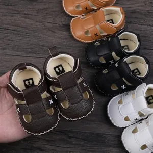 Detailed view of handmade baby leather sandals with X-stitch design in multiple colors