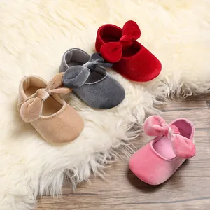 Close-up detail of soft velvet baby princess walking shoes with large bows in multiple colors