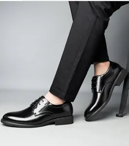Dettaglio laterale di scarpe eleganti in pelle nera lucida indossate con pantaloni.