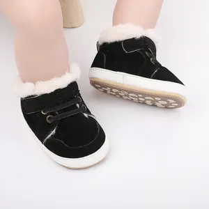 Nahaufnahme schwarzer Winter-Babyschuhe mit warmem weißem Kunstfellfutter