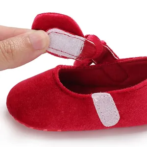 Macro detail showing adjustable velcro strap on red velvet baby princess walker shoe
