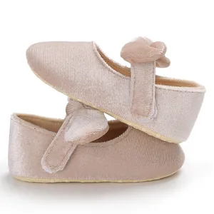 Detailed macro view of soft pink velvet baby princess shoes with a decorative knot strap