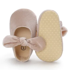 Close-up detail of non-slip dotted sole and velvet bow on pink baby princess shoes