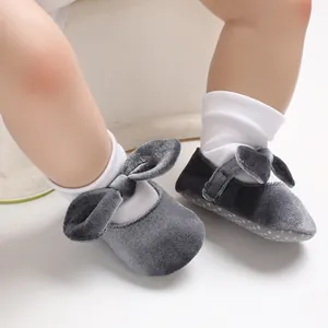 Detail view of soft grey velvet baby Mary Jane shoes with cute bows and velcro straps.