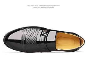 Top-down view of black glossy leather men's loafers with perforated detailing