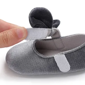 Close-up of grey velvet baby shoe showing the adjustable velcro strap functional detail