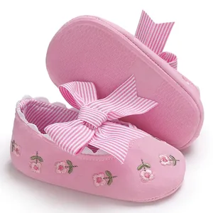 Vue détaillée des chaussures de marche bébé fille brodées roses avec semelle souple.