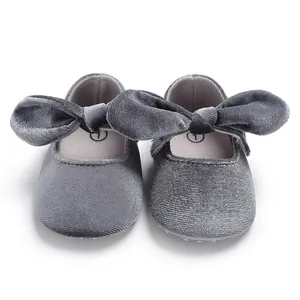 Close-up macro view of soft grey velvet baby princess shoes with large bow detail