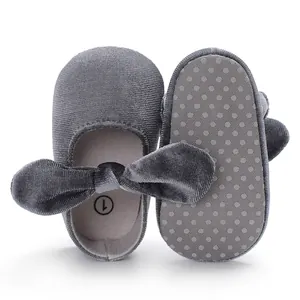 Macro detail view of grey velvet baby walker shoes with bow and non-slip soft sole