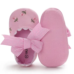 Vue détaillée de chaussures de princesse roses brodées pour bébé avec nœud rayé