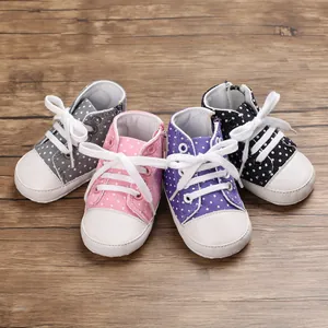 Nahaufnahme von gepunkteten Babyschuhen aus Segeltuch in Pink, Lila, Grau und Schwarz