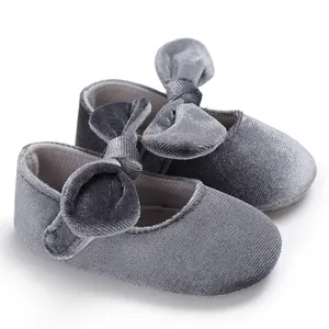 Macro view of soft grey velvet baby princess shoes featuring large decorative bows