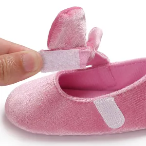 Close-up of pink velvet baby princess shoe showing hook-and-loop strap detail