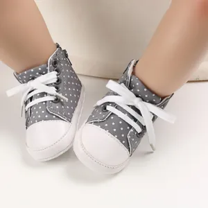 Detailansicht grauer Baby-Stoffschuhe mit weißen Punkten, weicher Sohle und Schnürsenkeln