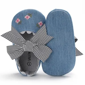 Vue détaillée de chaussures pour bébé en denim avec fleurs brodées et grand nœud