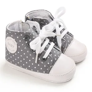 Graue gepunktete Baby-Leinenschuhe mit weicher Sohle und weißen Schnürsenkeln Nahaufnahme