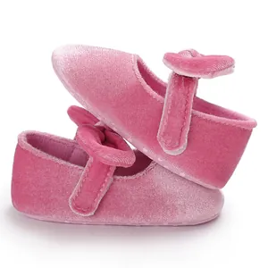 Close-up of pink velvet baby princess shoes with a soft sole and decorative bow detail