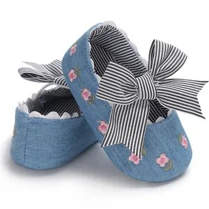 Gros plan de chaussures en denim pour bébé fille avec broderie et nœud