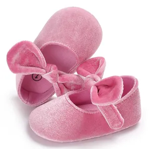 Detailed macro view of pink velvet baby princess shoes with a large bow and soft sole