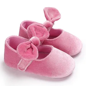 Detailed macro view of soft pink velvet baby shoes with elegant velvet bow detailing