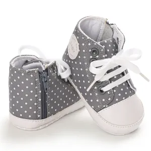 Nahaufnahme grauer Baby-Leinenschuhe mit weißen Punkten, Reißverschluss und Schnürsenkeln