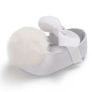 Vue détaillée chaussure bébé fille blanche avec pompon duveteux et nœud élégant