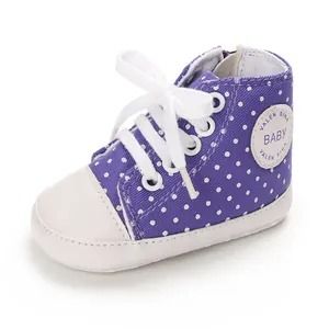 Detailansicht lila gepunkteter Baby-Leinenschuhe mit weichen weißen Sohlen und Schnürsenkeln.