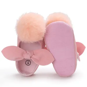 Vue détaillée de chaussures de princesse roses pour bébé avec pompons et semelle souple