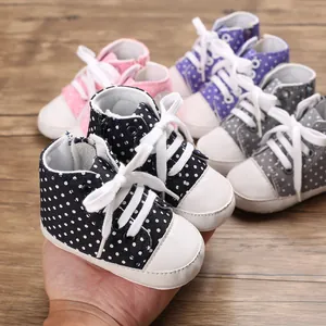 Nahaufnahme von niedlichen gepunkteten Baby-Leinenschuhen mit weichen Sohlen in bunten Farben