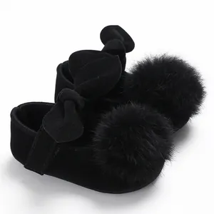 Vue détaillée de chaussures de princesse noires pour bébé avec noeud décoratif et pompon en peluche
